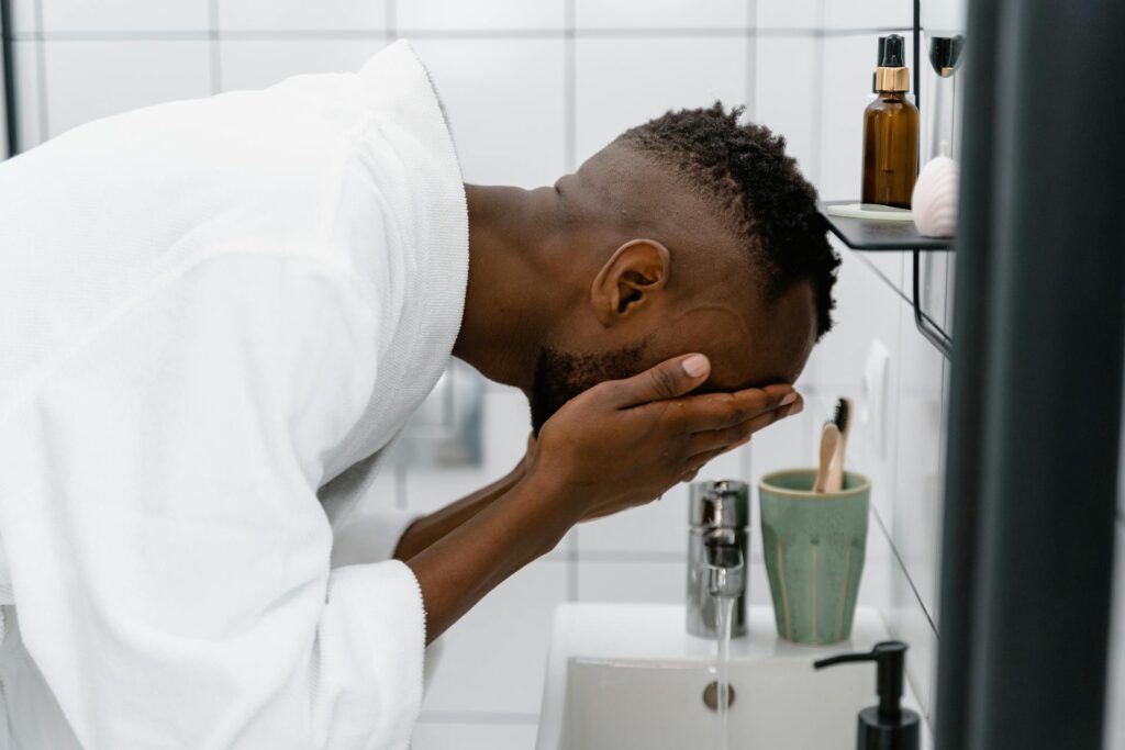 man washing face during evening skincare routine for men